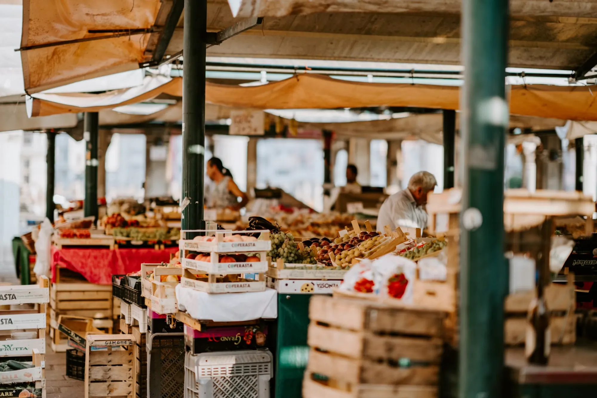 Covered produce market with crates of fruit and vegetables